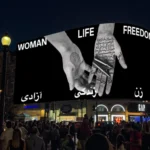 Protesters gathered last night in support of the women of Iran at London's Piccadilly Circus where Shirin Neshat's Woman Life Freedom commission was screened Courtesy of Circa and the artist