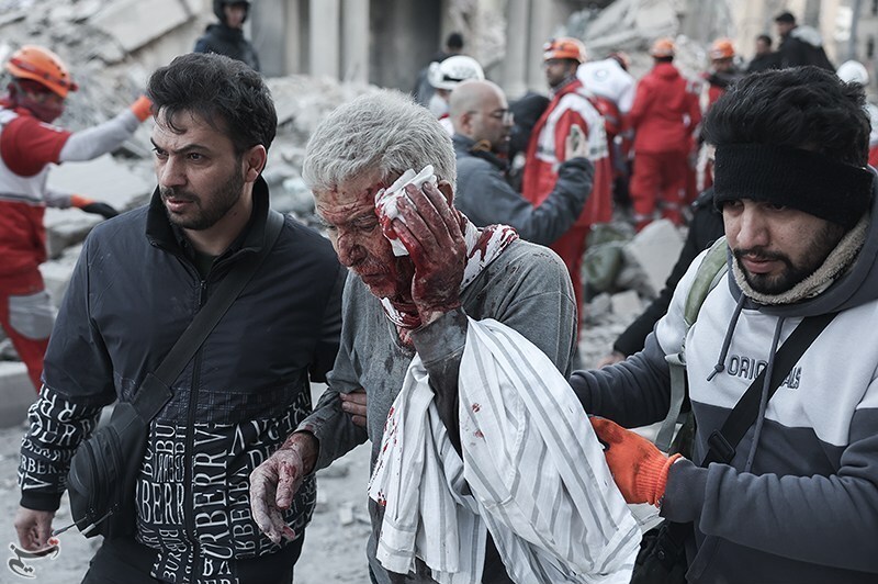An elderly man is shepherded to safety in the bloody aftermath of an attack by US-Israeli warplanes on the area in and around Tehran's Enqelab (Revolution) Square on 3 March 2026, which left scores dead and gravely wounded as well as extensive damage to residences and civilian infrastructure | Tasnim News Agency | Creative Commons Attribution 4.0 International License
